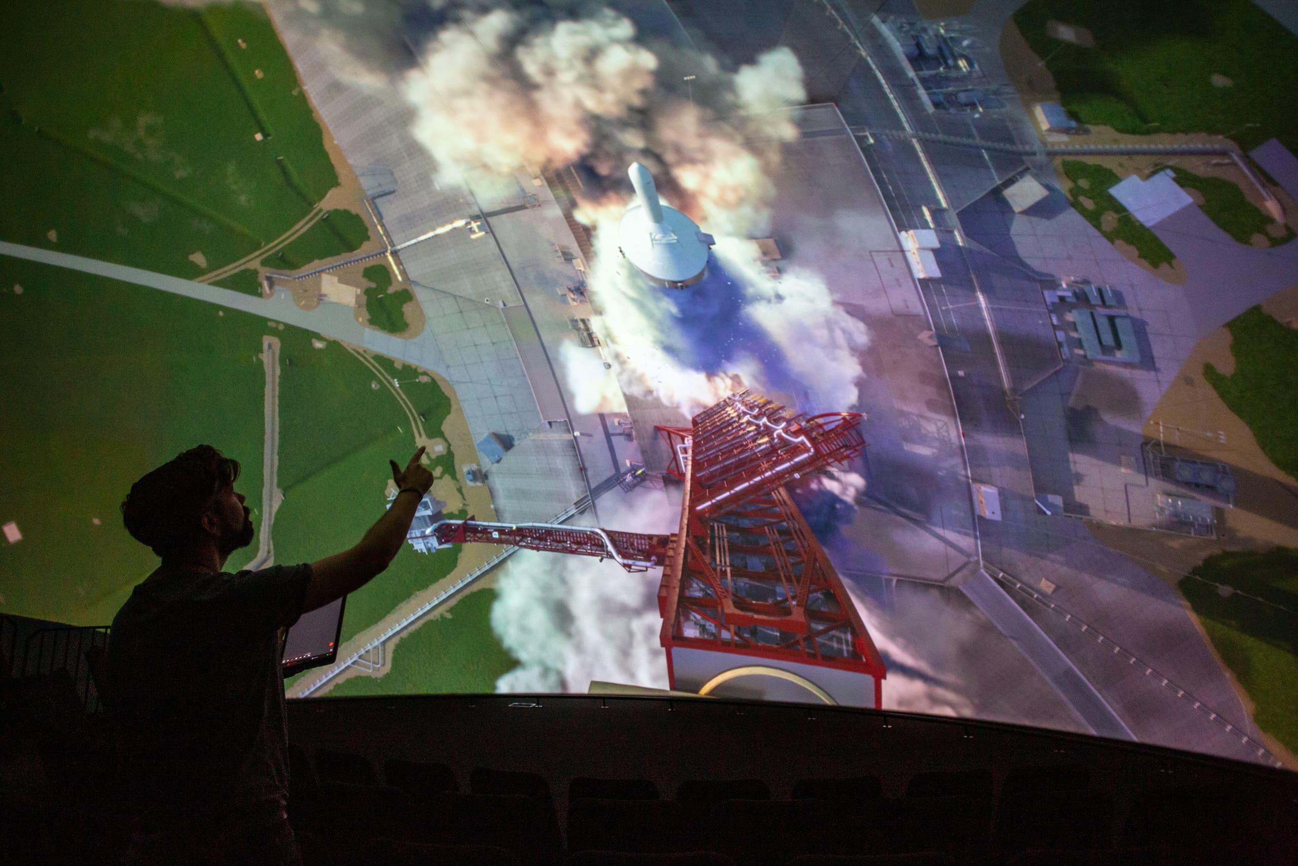 A person viewing the immersive screen while holding a tablet controller.