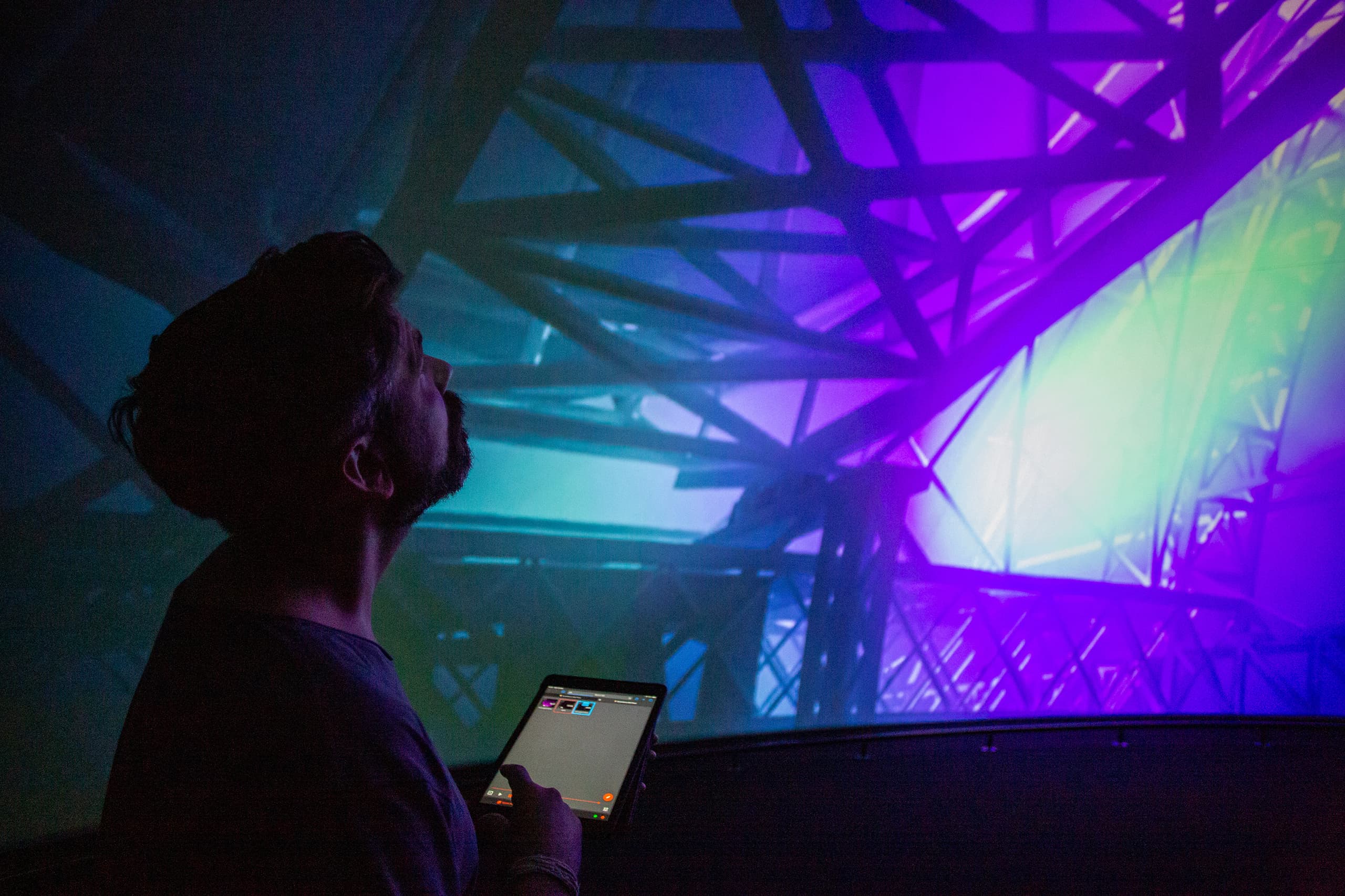 A person viewing the immersive screen while holding a tablet controller.